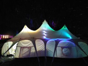 Ein großes weißes Zelt dass fast wie eine Knoblauchknolle aussieht und von innen mit bunten LEDs beleuchtet wird